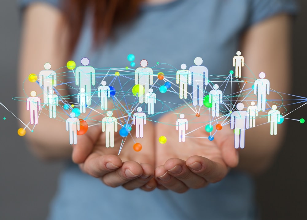 Un paire de main paumes vers le haut, présentant un image virtuelle de personnes reliées entres elles par des liens symbolisant le codéveloppement professionnel.