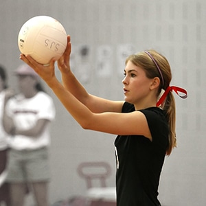 Vu de profil d'une joueuse de volley ball prête à servir