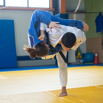 Une prise de judo photographiée en plein mouvement.