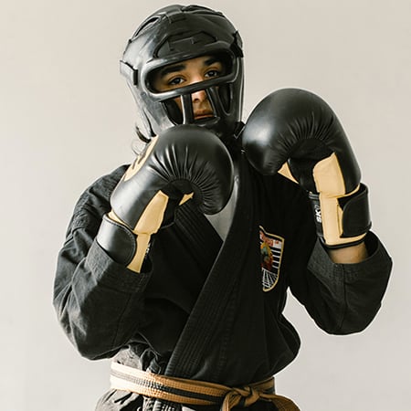 Vu de face d'une jeune femme dans sa tenue de Yoseikan Budo en position défensive