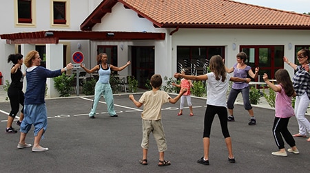 Des adultes et des enfants pratiquent la Zumba en cercle